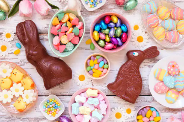 An assortment of colorful Easter candies and chocolates arranged on a wooden table.