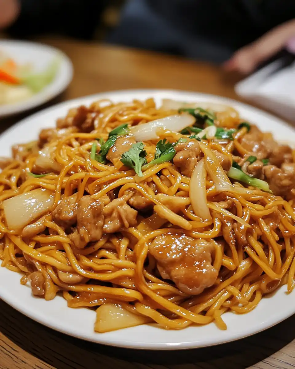 Final stir-fry step of Cantonese chow mein in wok with all ingredients combined