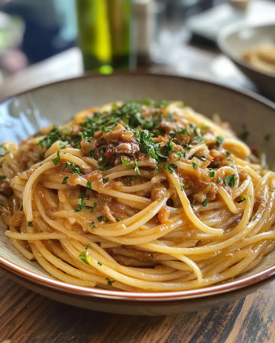 Finished plate of caramelized onion chili oil spaghetti with parsley garnish