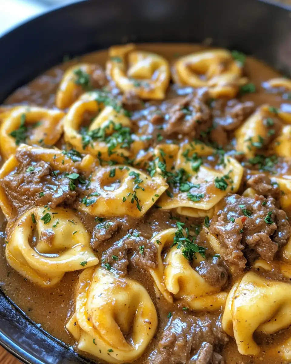 Cheesesteak tortellini cooking with rich provolone sauce steaming