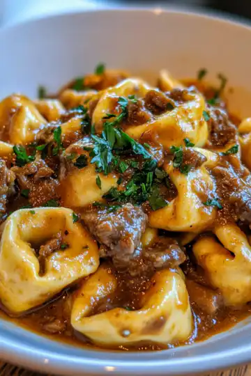 Cheesesteak Tortellini In Rich Provolone Sauce taken with iphone 15 pro max --iw 2 --ar 4:5 --v 6.1 --raw