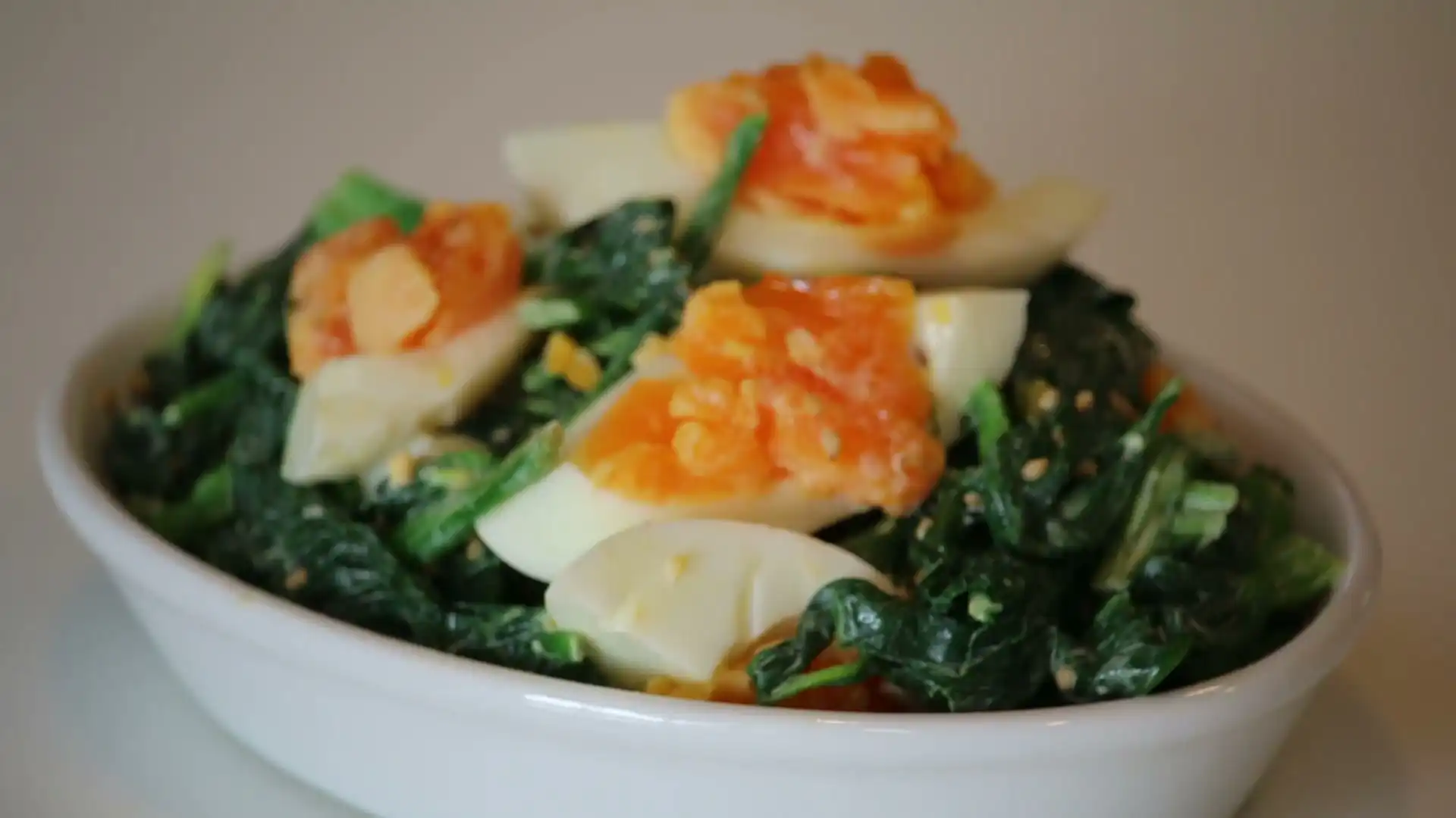 Close-up of Spinach Salad With Bacon And Eggs showing the texture and color detail
